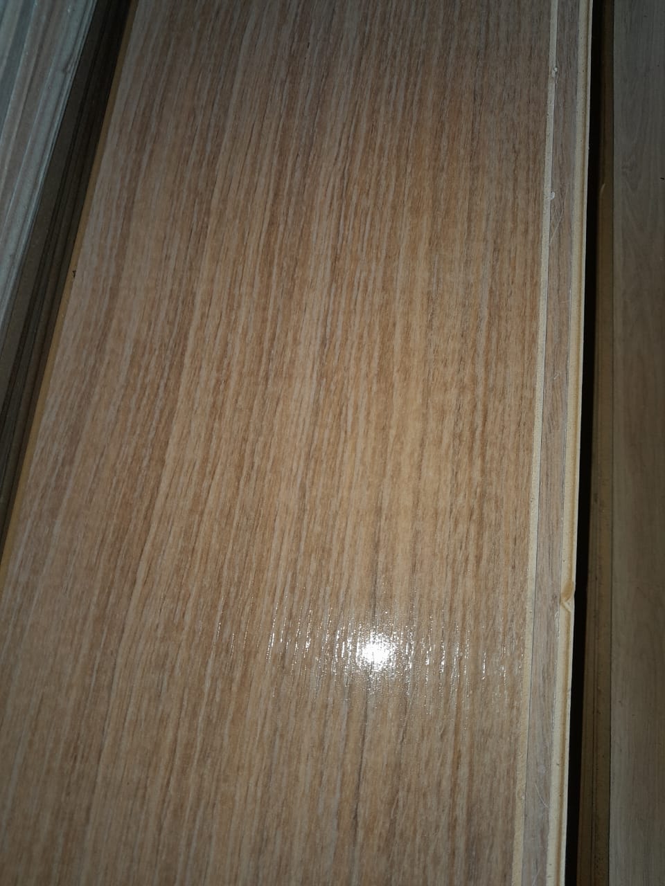 Close-up de tábuas de madeira com acabamento envernizado, evidenciando a qualidade e o veio do material reutilizado vendido pela loja.